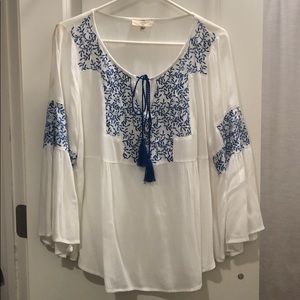 White woven top with blue embroidery detail